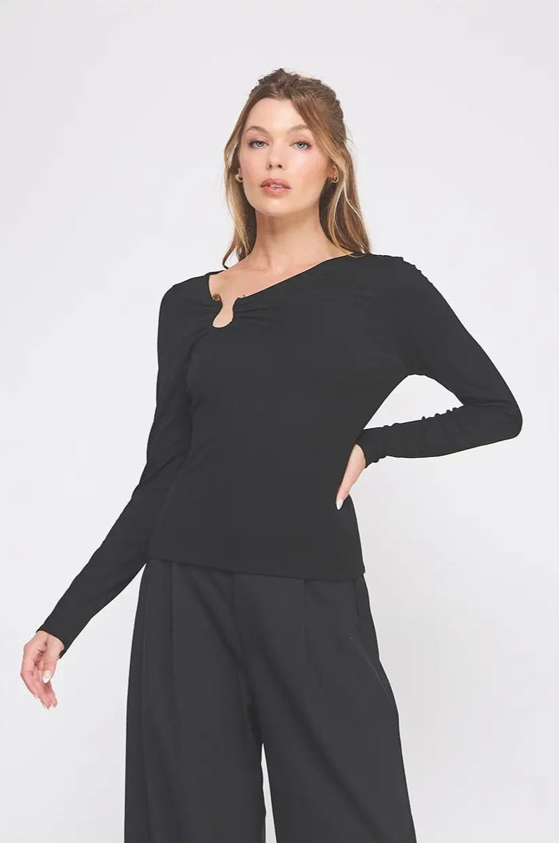 Woman wearing a black long-sleeve top and black pants on a white background