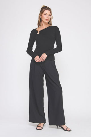 Woman wearing a black outfit with wide-leg pants on a white background