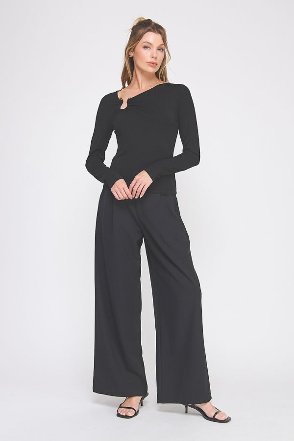 Woman wearing a black outfit with wide-leg pants on a white background