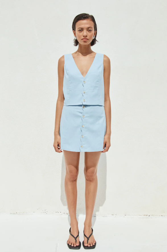 A woman wearing a light blue sleeveless vest 