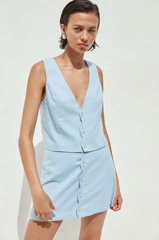A woman wearing a light blue sleeveless vest 