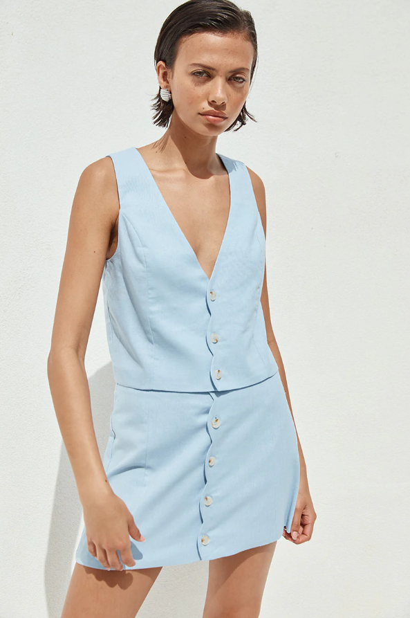 A woman wearing a light blue sleeveless vest 