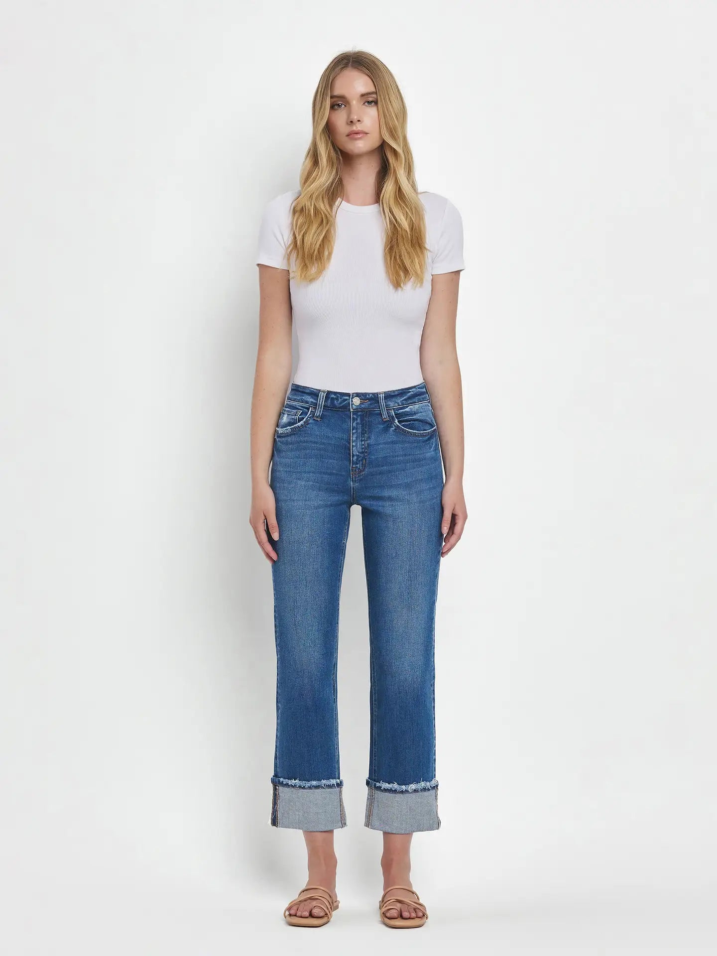 Woman wearing blue jeans and a white t-shirt on a white background