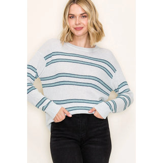 Woman wearing a light blue and white striped sweater against a plain background