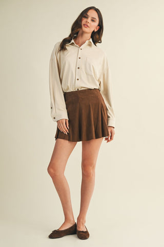 Woman wearing a white blouse and brown skirt on a beige background