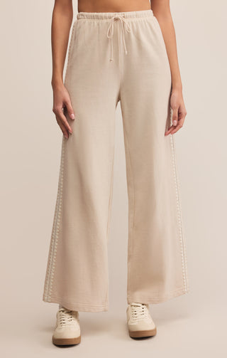 Beige wide-leg pants worn by a person on a beige background