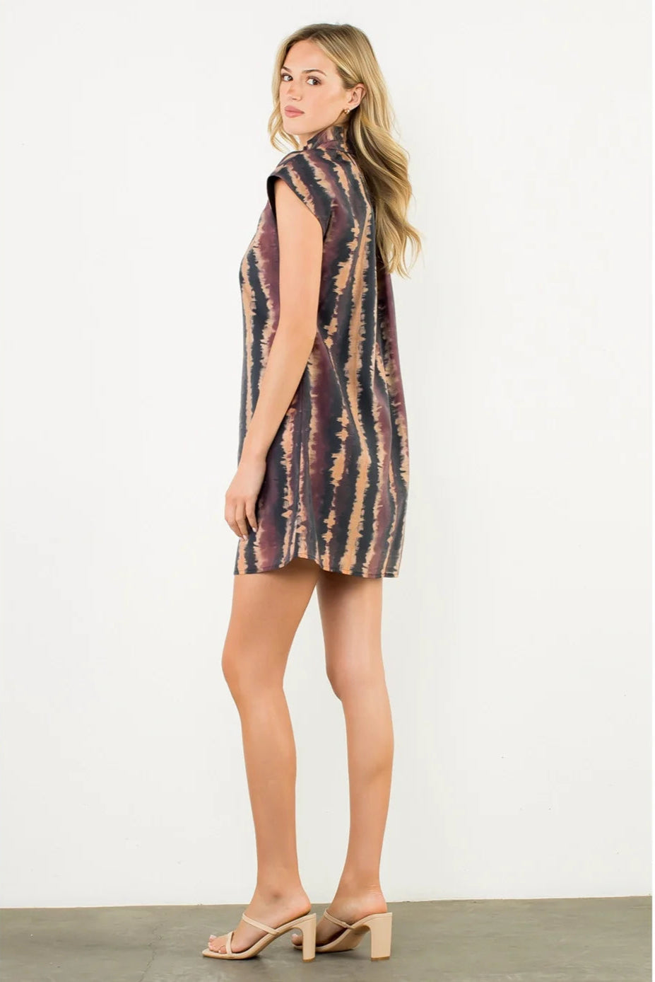 Woman wearing a sleeveless tie-dye dress on a white background