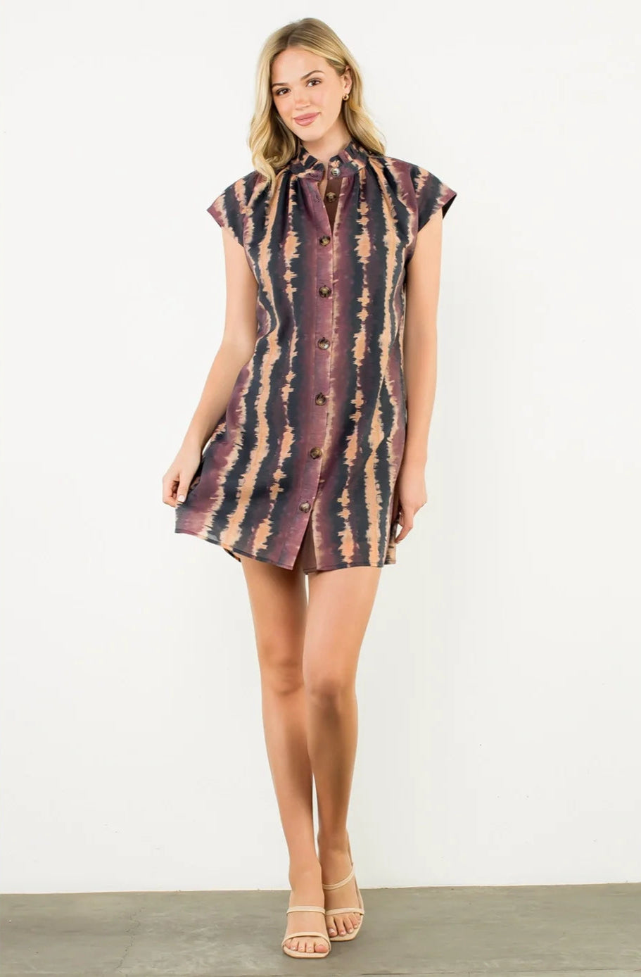 Woman wearing a patterned dress on a white background