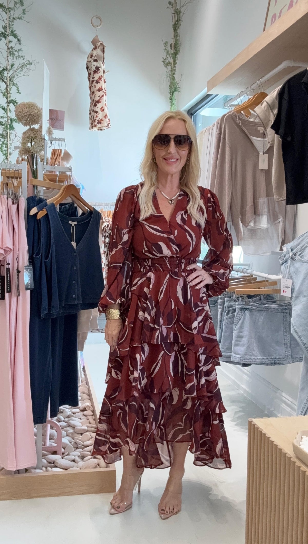 Woman in a patterned dress standing in a clothing store