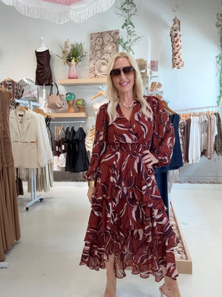 Woman in a patterned dress standing in a clothing store