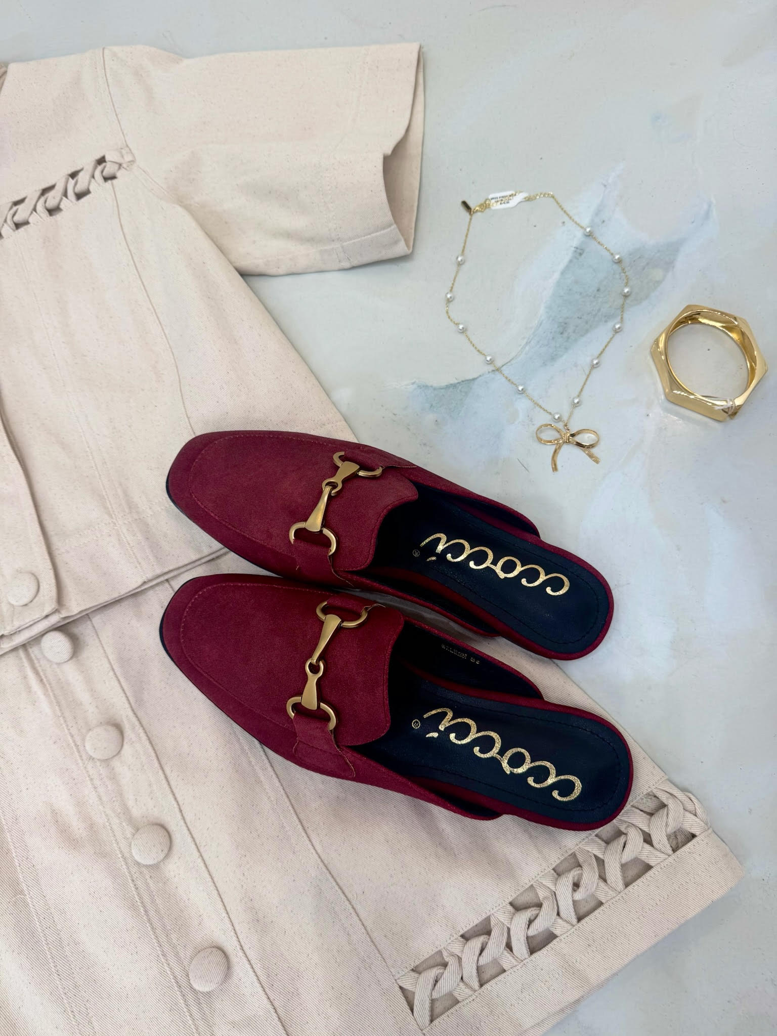 Maroon slip-on shoe with gold buckle on a white background, featuring the brand 'cccoo'.