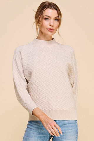 Woman wearing a beige sweater against a beige background