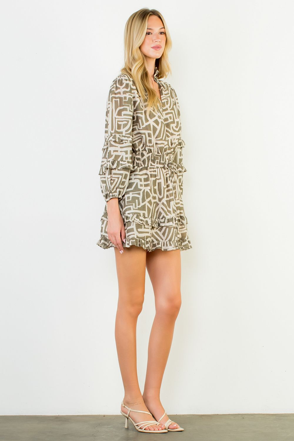 Woman wearing a patterned dress against a white background