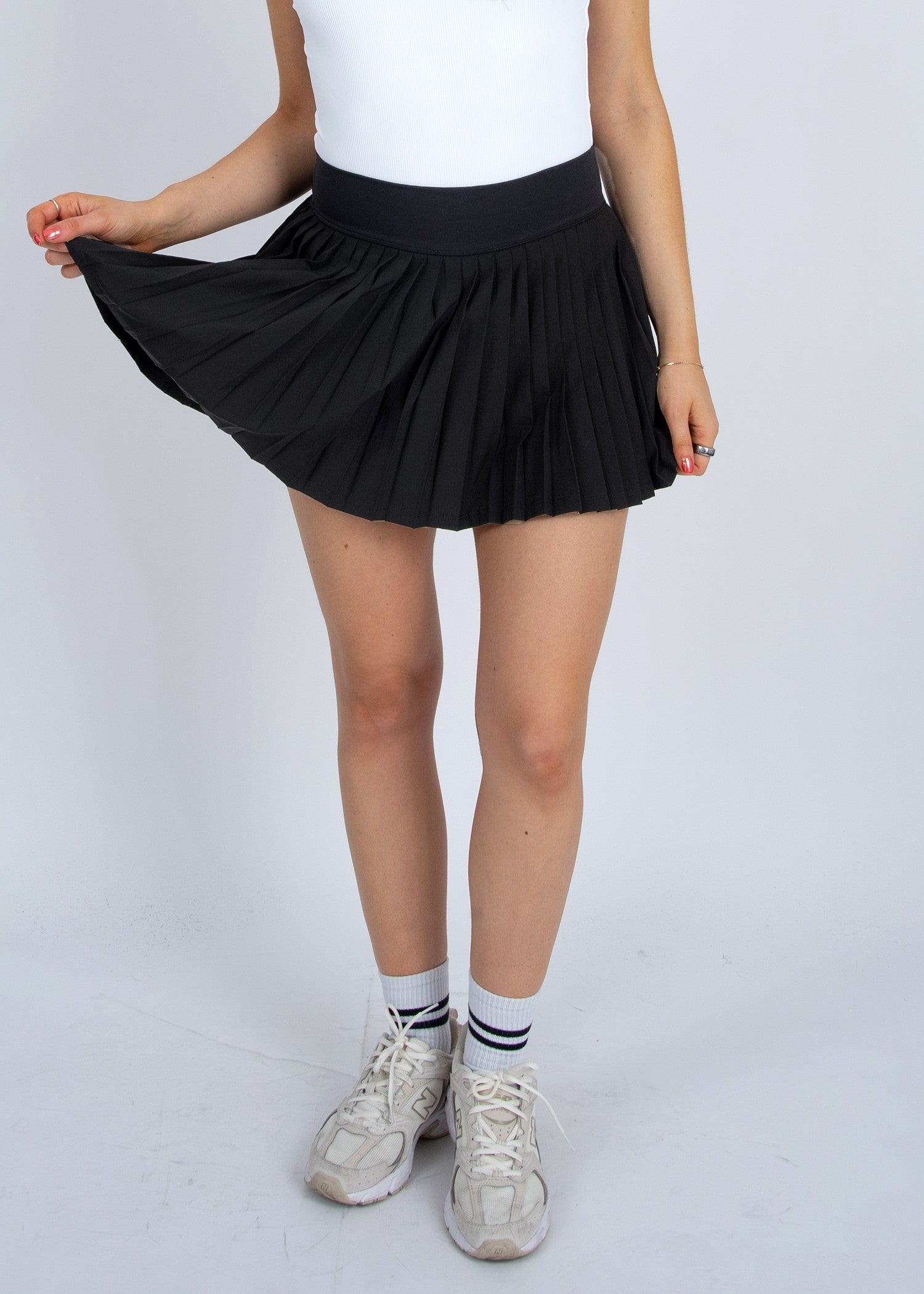 YURA PLEATED MINI SKIRT in black styled for an elegant everyday look