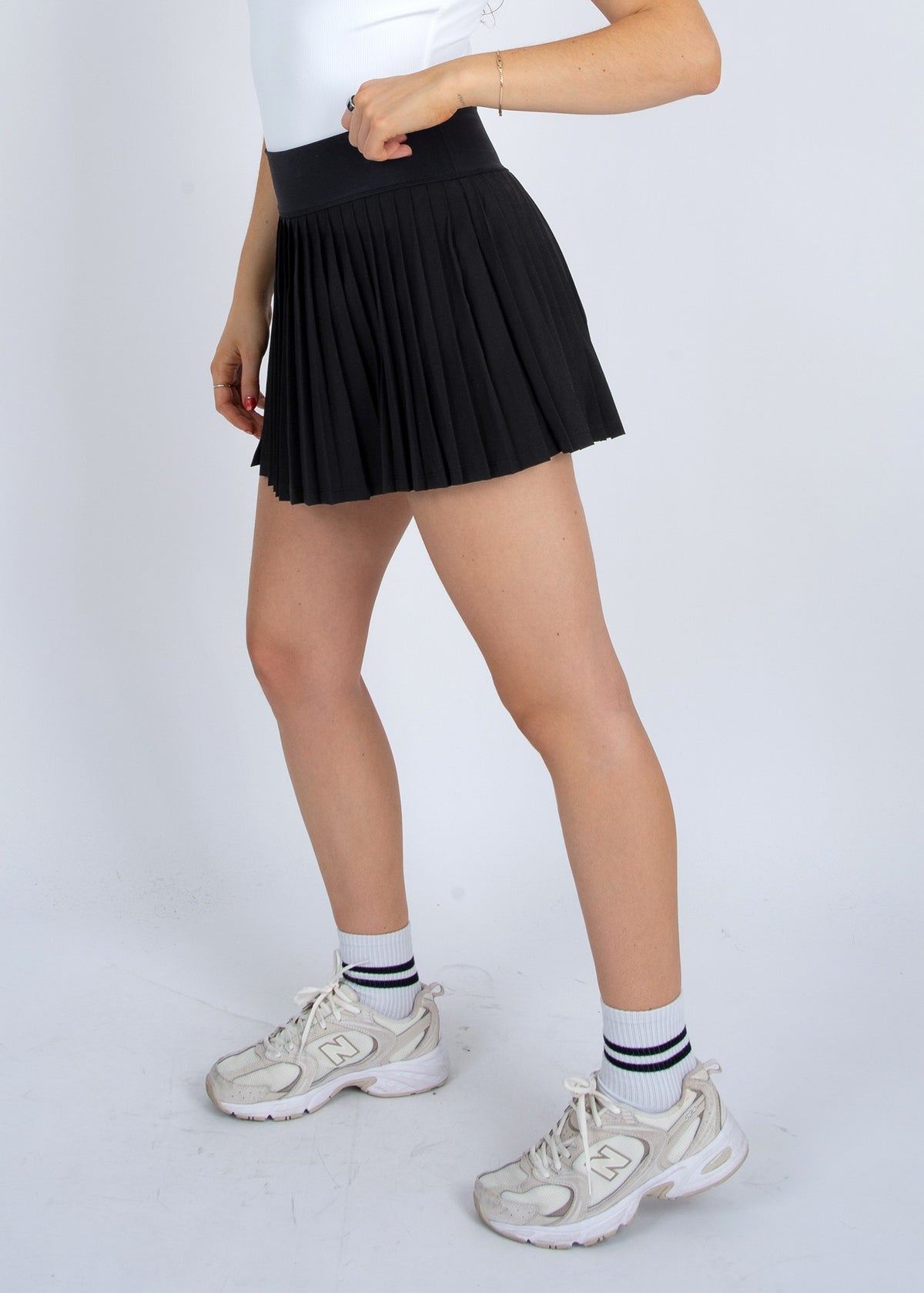 Front view of STMT BOUTIQUE YURA PLEATED MINI SKIRT in black